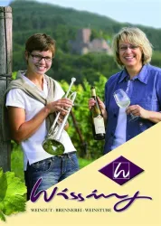 Zwei Frauen stehen in einem Weinberg. Eine hält ein Glas Wein, während die andere eine Trompete trägt.