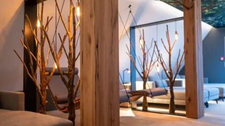 Ein moderner Raum mit Holzsäulen und kreativen Baum-Elementen. Die Beleuchtung schafft eine gemütliche Atmosphäre.