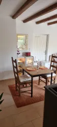 Ein gemütlicher Essbereich mit einem Holztisch und Stühlen. Der Raum hat eine helle Atmosphäre und dekorative Elemente.