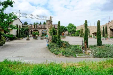 Ein schöner Innenhof mit Pflanzen und Sitzgelegenheiten. Die Umgebung ist von natürlichen Elementen und Gebäuden im rustikalen Stil geprägt.