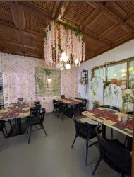 Ein schön dekoriertes Restaurant mit blühenden Wänden und stilvollen Möbeln. Die warmen Lichter schaffen eine einladende Atmosphäre.