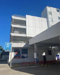 Ein Parkplatzgebäude mit moderner Architektur und einem klaren blauen Himmel. Im Vordergrund steht ein Schild mit der Kennzeichnung "P3".