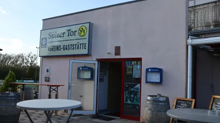 Ein Vereinsgasthaus mit dem Namen "Sülzer Tor". Der Eingang ist gut sichtbar, und es gibt einige Sitzmöglichkeiten im Freien.