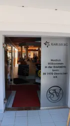 Ein einladender Eingang zu einer Gaststätte mit einem Empfangstresen. Der Raum ist hell und freundlich gestaltet.