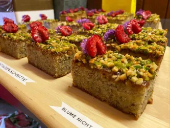 Kleine Kuchen mit Himbeeren und Blüten dekoriert