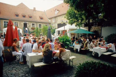 Innenhof Von-Busch-Hof mit Tischen, Bänken und Gästen