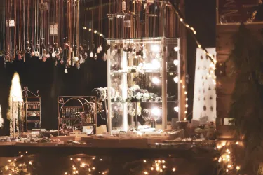 Ein gemütlicher Verkaufsstand mit Schmuck in einer Vitrine. Sanfte Lichter schaffen eine einladende Atmosphäre.