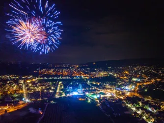 Ein beeindruckendes Feuerwerk über einer Stadt bei Nacht. Die Lichter funkeln und beleuchten die Umgebung.