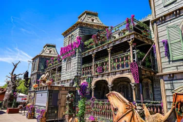 Eine beeindruckende, kunstvoll dekorierte Fassade eines historischen Gebäudes. Vorne sind Pflanzen und Blumen angebracht, die eine lebendige Atmosphäre schaffen.