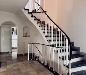 Eingangsbereich mit Blick auf die Treppe zum ersten Obergeschoss und Treppe in den Keller