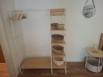 Ein moderner Kleiderständer mit Holzregalen und mehreren Körben. Die Wand ist in hellen Farben gehalten und bietet eine freundliche Atmosphäre.