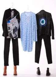 Drei verschiedene Outfits hängen an Kleiderbügeln. Dazu gehören eine blaue Nachthemd, eine schwarze Lederjacke und eine schwarze Hose.