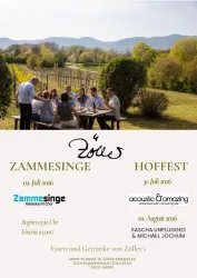 Eine Gruppe von Menschen sitzt entspannt an einem Tisch im Freien und genießt die Aussicht auf Weinberge. Im Hintergrund sind sanfte Hügel und ein klarer Himmel zu sehen.