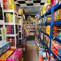 Ein übersichtlicher Laden mit Regalen voller Räucherstäbchen-Produkte in verschiedenen Farben. Der Raum hat einen klaren und geordneten Eindruck.