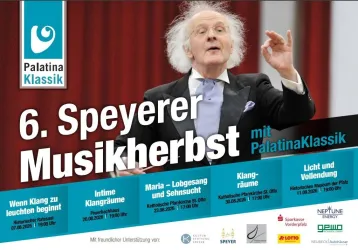 Ein Mann steht auf der Bühne und dirigiert mit leidenschaftlicher Gestik. Im Hintergrund sind Informationen zu einem Musikfestival in Speyer abgebildet.