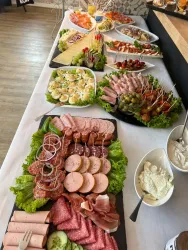 Ein reichhaltiges Buffet mit verschiedenen Wurst- und Käseplatten, frischen Salaten und Snacks. Bunte Beilagen und Dekorationen machen das Angebot ansprechend.
