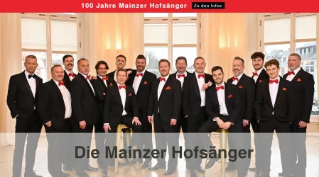 Eine Gruppe von Männern in formeller Kleidung steht zusammen. Sie tragen schwarze Anzüge mit roten Fliegen und lächeln für die Kamera.
