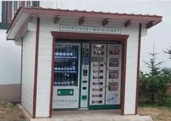 Eine kleine Weinverkaufsstation im Freien mit einem modernen Automaten. Der Automat bietet verschiedene Weinsorten zum Kauf an.