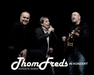 Drei Männer stehen auf der Bühne und präsentieren akustische Songs. Sie singen und spielen Gitarre in einem dunklen Raum.