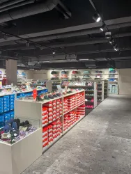 Ein moderner Schuhladen mit Regalen voller Schuhe in verschiedenen Farben. Die Beleuchtung ist hell und schafft eine einladende Atmosphäre.