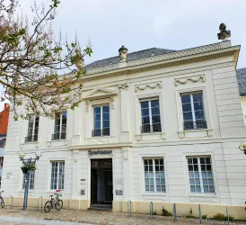 Ein historisches Gebäude der Sparkasse mit eleganter Architektur. Es hat große Fenster und eine klassische Fassade.