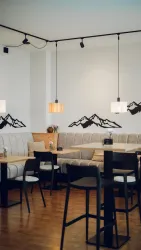 Ein modernes Café mit gemütlichen Sitzbereichen und einer minimalistischen Einrichtung. An der Wand sind stilisierte Bergmotive zu sehen.