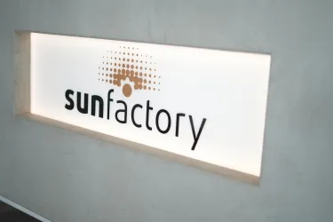 Ein modernes Logo der Marke "sunfactory" ist auf einem hellen Hintergrund zu sehen. Die Gestaltung wirkt klar und ansprechend.