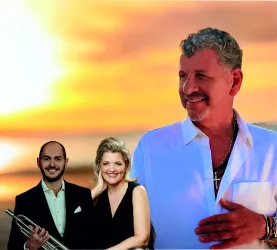 Drei Musiker stehen vor einem malerischen Sonnenuntergang. Sie strahlen Freude und Leidenschaft für ihre Musik aus.