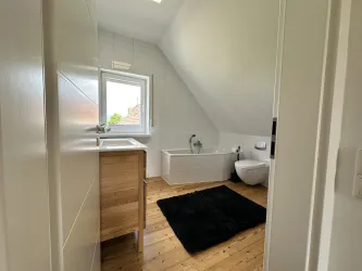 Badezimmer mit Waschbecken, Badewanne und WC.