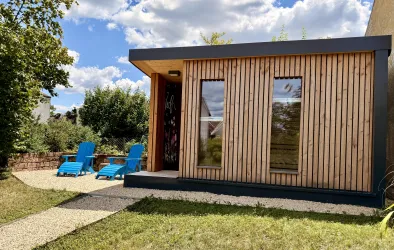 Gartensauna mit Kaltwasserdusche und Liegestühlen.