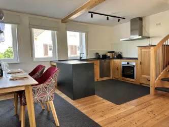 Küche und Essbereich. Große Fenster sorgen für viel Licht und eine einladende Atmosphäre.