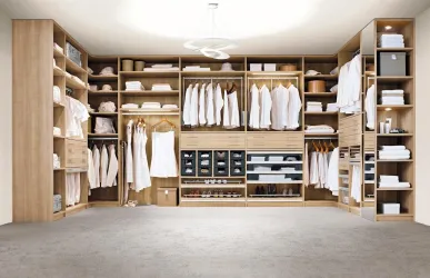 Ein moderner begehbarer Kleiderschrank aus Holz mit ordentlich hängender und gefalteter Kleidung. Der Raum ist hell erleuchtet und vermittelt ein Gefühl von Ordnung und Stil.