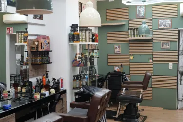 Ein modernes Friseurstudio mit Stühlen und Kosmetikprodukten an den Wänden. Die Wände sind in sanften Farben gestaltet und es fühlt sich einladend an.