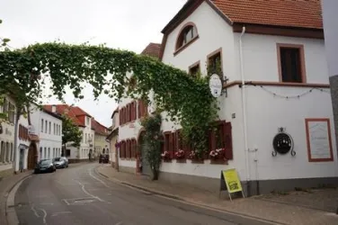 Eine charmante Straße mit typischen deutschen Fachwerkhäusern. Über der Straße hängt ein grüner Wein.