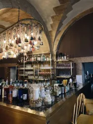 Eine stilvolle Bar mit einem eleganten Thekenbereich und einer großen Auswahl an Spirituosen. Die dekorativen Lichtinstallationen schaffen eine gemütliche Atmosphäre.