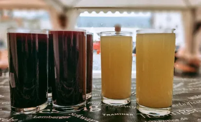 Zwei Gruppen von Getränken stehen auf einem Tisch. Die Gläser enthalten rote und helle Flüssigkeiten.