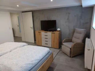Schlafzimmer mit TV (© Archiv Ferienwohnung in der Grünheck)
