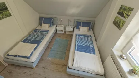 Ein helles Schlafzimmer mit zwei Einzelbetten.