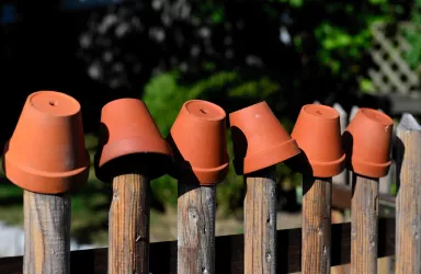 Tontöpfe auf Gartenzaun
