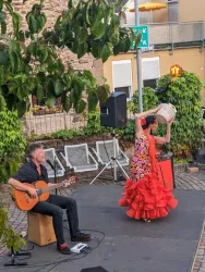 Flamencotänzerin im roten Kleid und Musiker mit Gitarre bei ihrem Auftritt bei der Spanischen Nacht