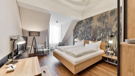 Ein modernes Hotelzimmer mit einem großen Bett und einem stilvollen Holzdesign. Die Wände sind mit einem auffälligen Muster dekoriert, das dem Raum Charakter verleiht.