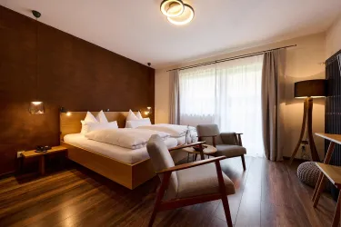 Ein modernes Zimmer mit zwei Betten und stilvollem Holzdesign. Große Fenster fluten den Raum mit natürlichem Licht.