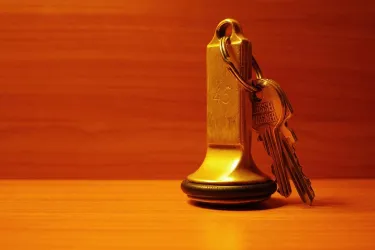 Ein Schlüsselanhänger mit einem goldenen Schlüssel und einer Nummer 43. Der Hintergrund ist aus warmem Holz und schafft eine gemütliche Atmosphäre.