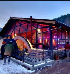 Ein modernes Restaurant mit einem gemütlichen Außenbereich. Bunte Lichter schaffen eine einladende Atmosphäre.