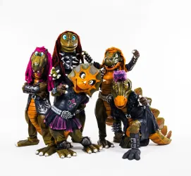 Fünf fantasievolle Dinosaurier-Figuren in auffälligen Kostümen stehen zusammen. Sie tragen bunte Haare und Accessoires, die ihren individuellen Stil zeigen.