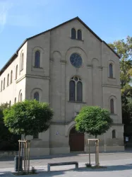 Ein lächelnder Musiker steht an einem Klavier. Die Perspektive zeigt die Innenseite des Klaviers und vermittelt eine freundliche Atmosphäre.