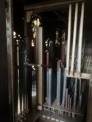 Eine Orgel mit verschiedenen Pfeifen in unterschiedlichen Farben und Größen. Die Struktur ist aus Holz und zeigt kunstvolle Details.