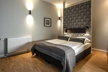 Ein modernes Schlafzimmer mit einem großen Bett und elegantem Dekor. Die Wände sind in sanften Farben gehalten, und es gibt sanfte Beleuchtung.