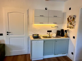 Eine moderne Küche mit hellblauen Schränken, einer Spüle und einem Geschirrspüler. Die Wand ist mit verschiedenen Küchenutensilien dekoriert.