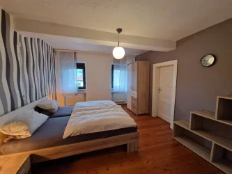 Ein modernes Schlafzimmer mit Doppelbett und Holzfußboden.